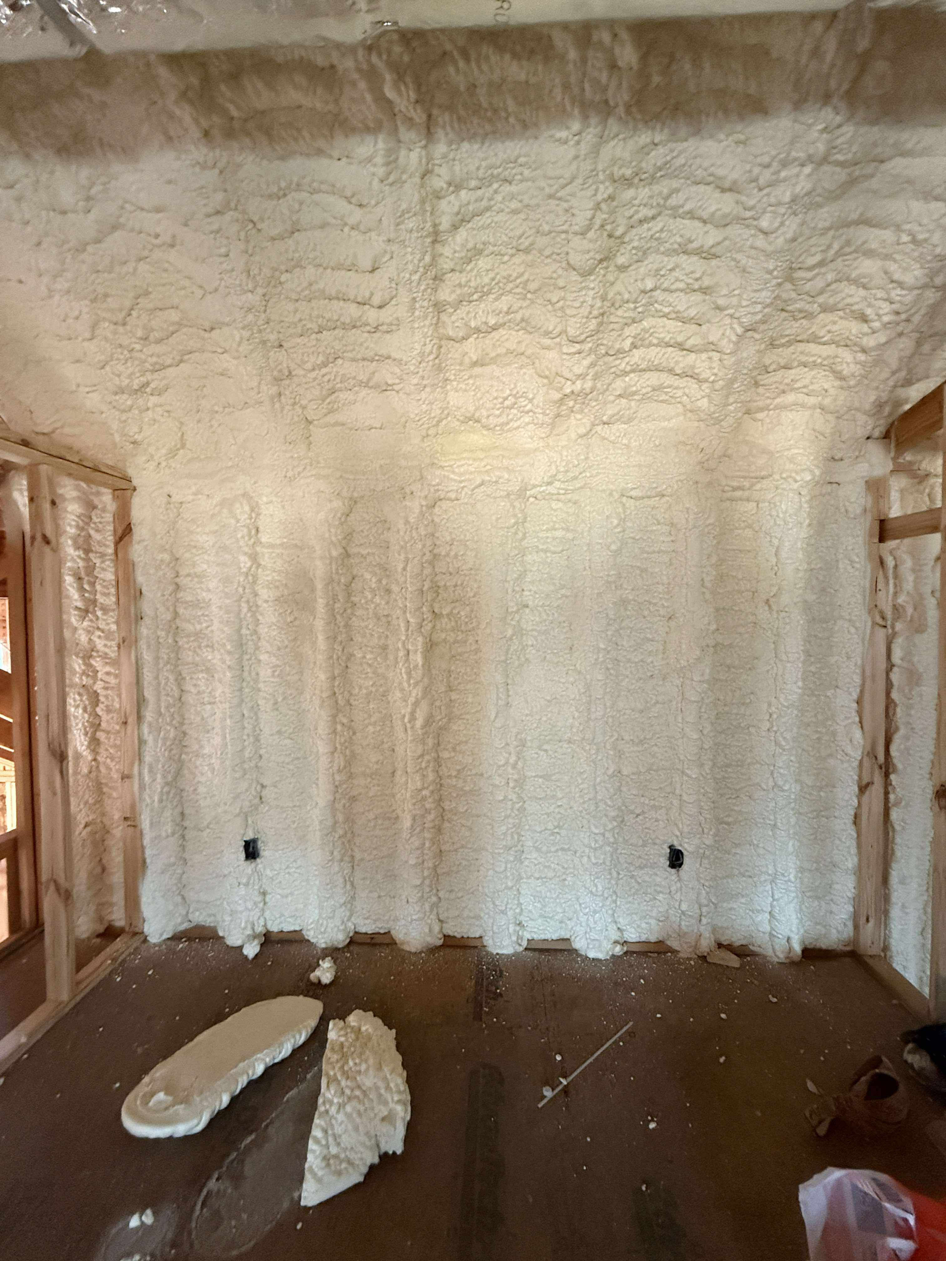 Technician applying foam in metal building