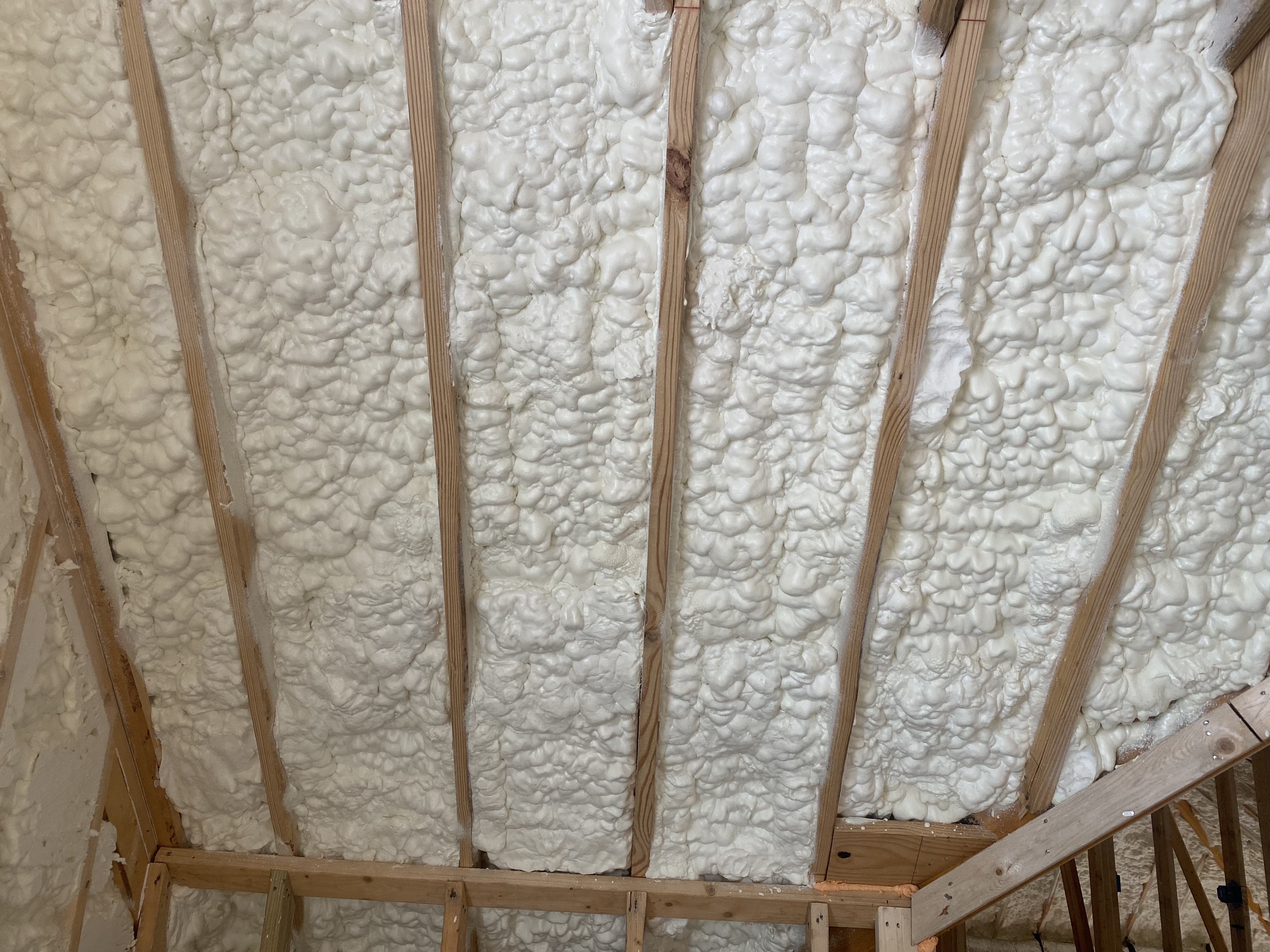 Crew spraying foam on roofline