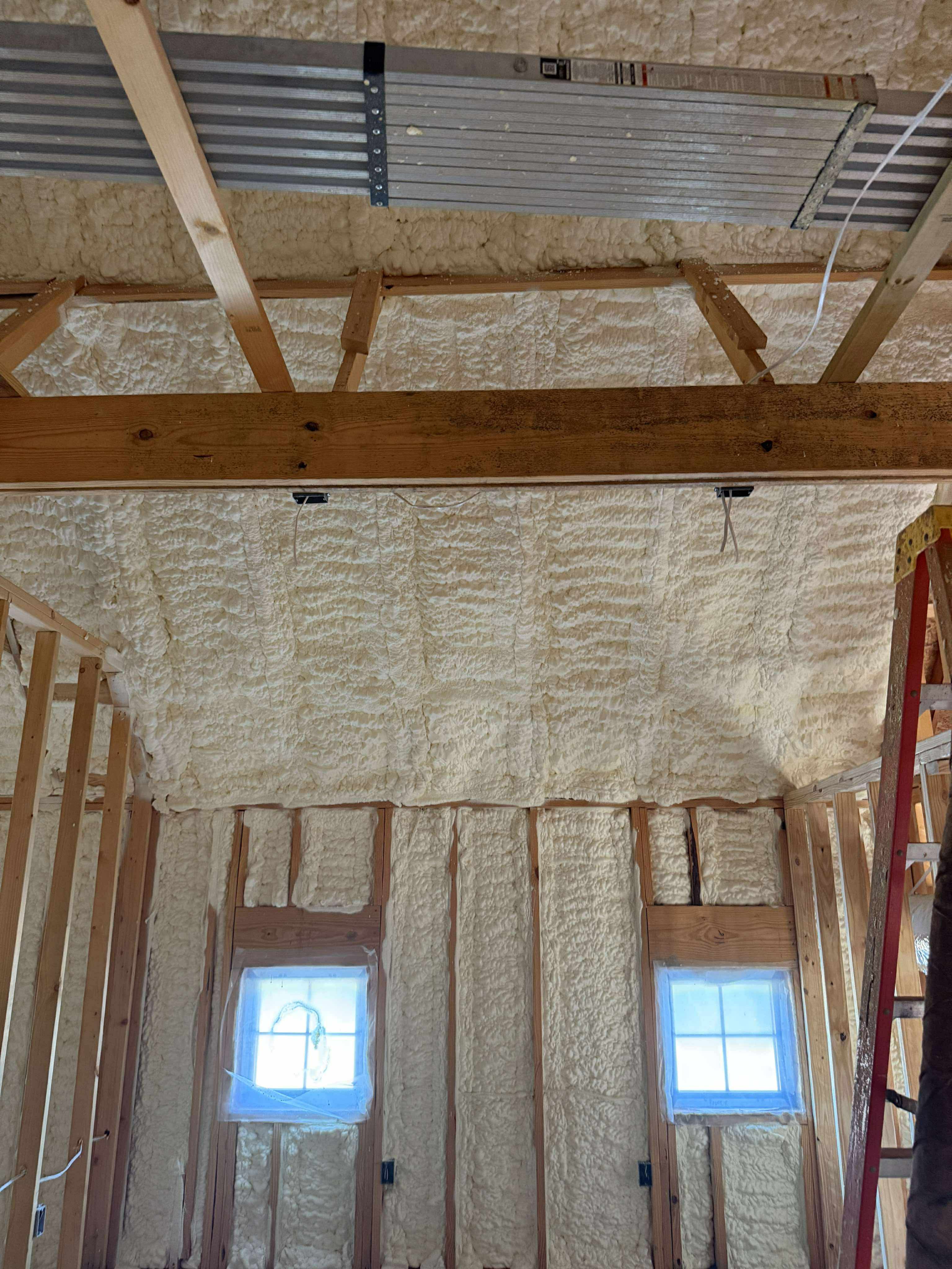 Spray foam coating a metal wall interior