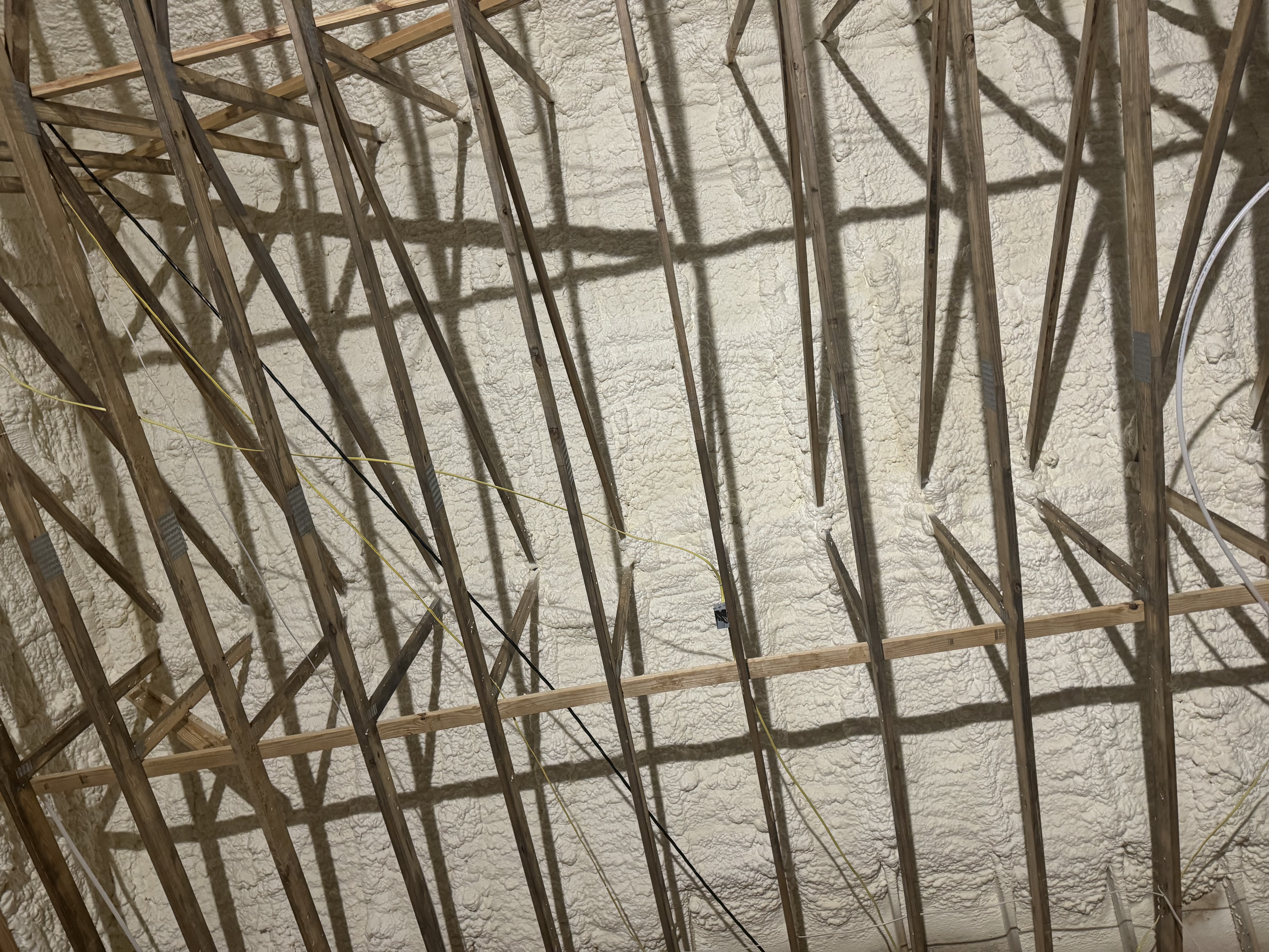 Spray foam sealing roof rafters and studs